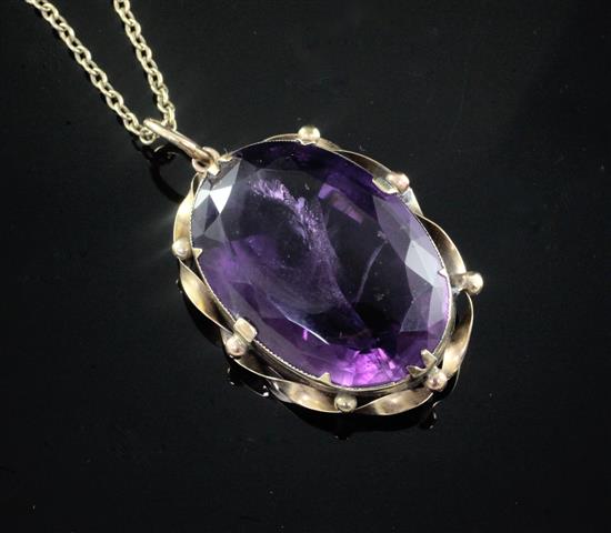 A large oval facet cut amethyst pendant in yellow metal mount on 9ct gold fine link chain, pendant 44mm.